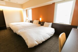 Una habitación de hotel con cama doble, escritorio y silla.