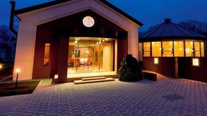 A building with a glass entrance, a circular skylight, and a brick facade.