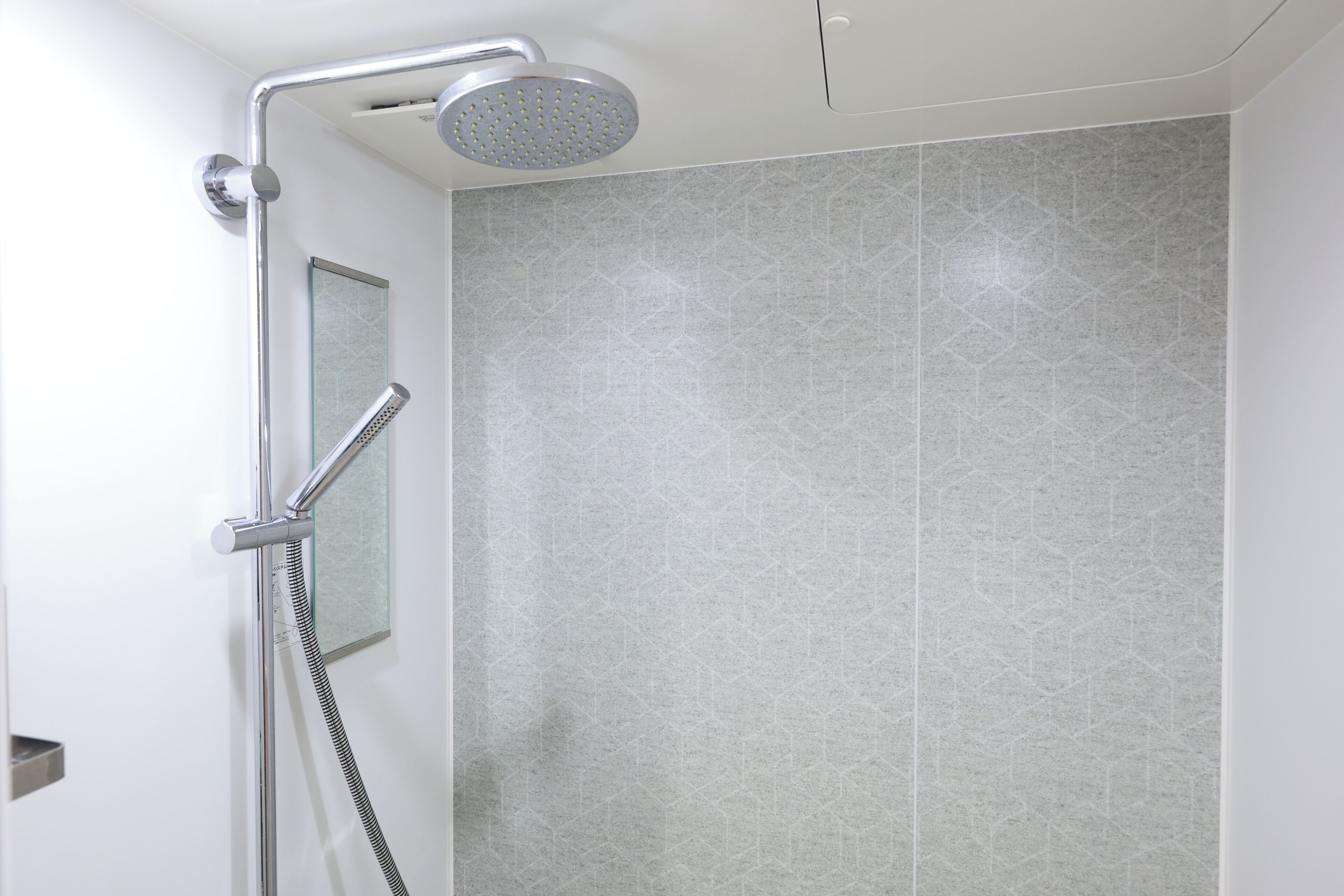 A shower with a handheld showerhead and a handheld hose.