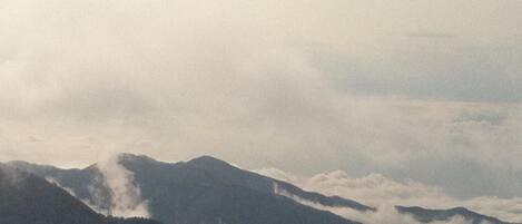 A mountainous landscape with clouds at the base of the peaks.