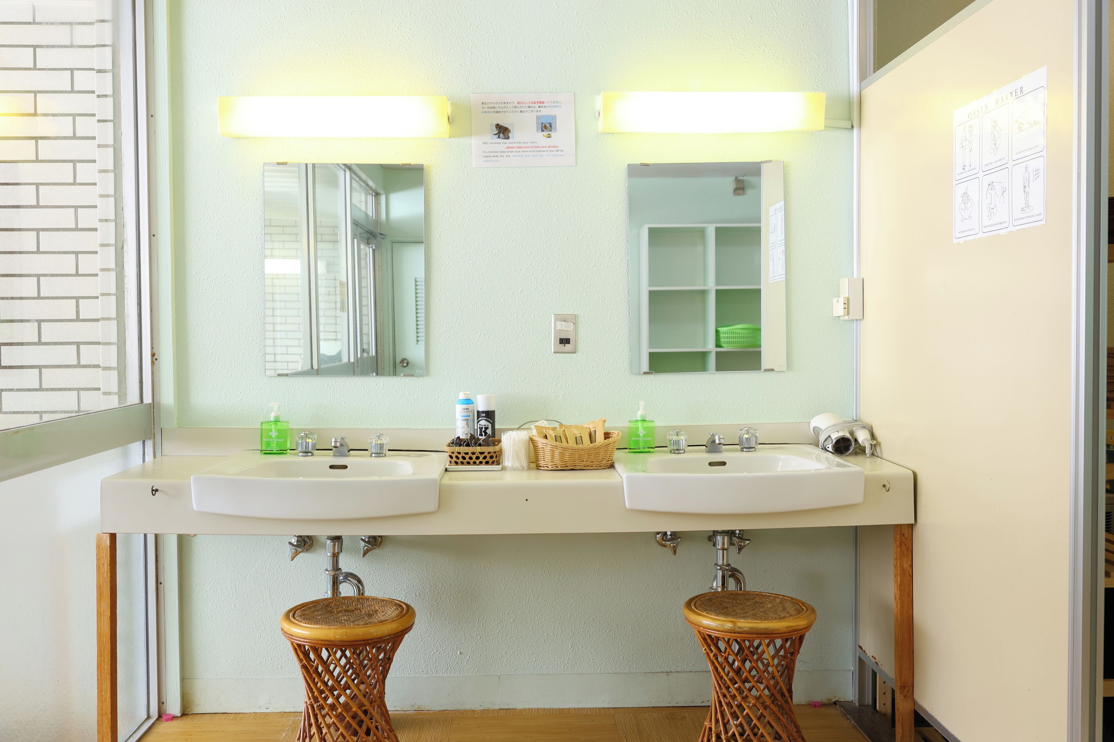 A bathroom with two sinks, a mirror, and a wooden stool.