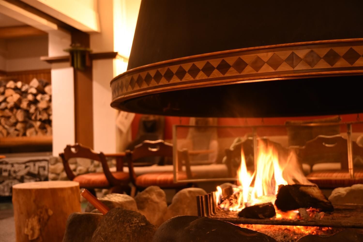 A fireplace with a decorative surround, logs, and a fire burning.