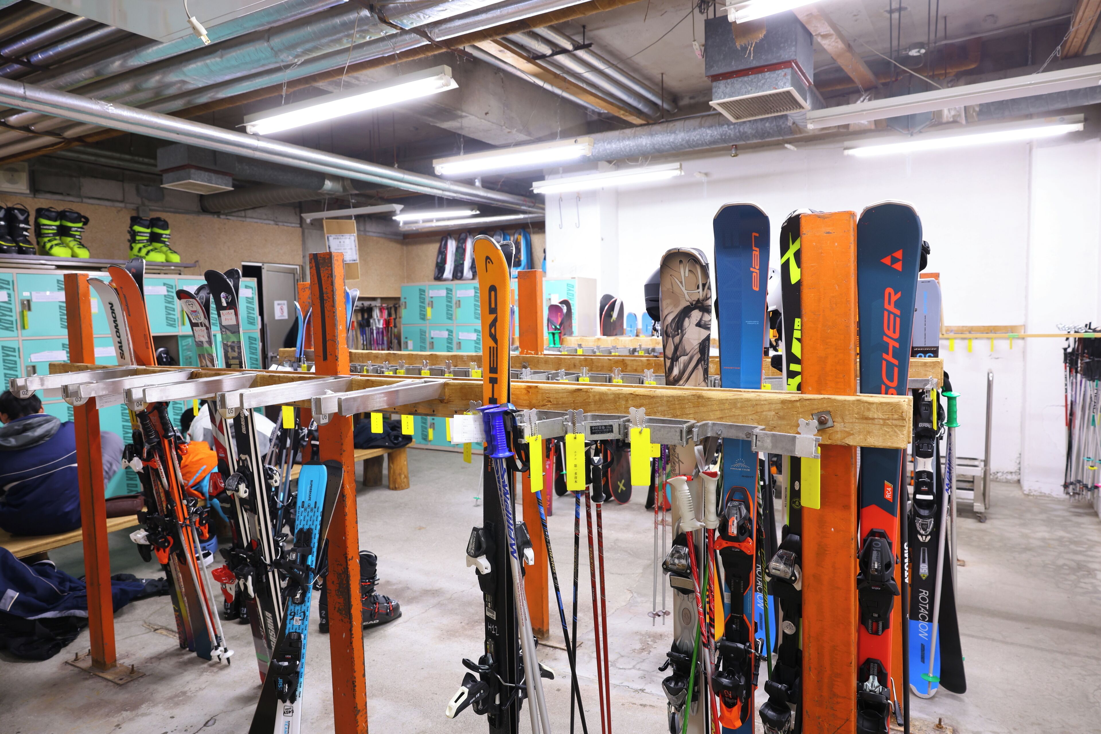 A ski equipment rental shop with rows of skis and snowboards on racks.