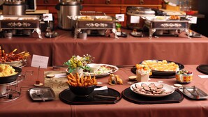 Een buffet met diverse gerechten en bestek.
