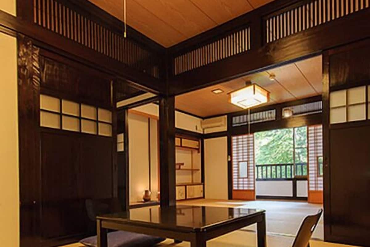 Perinteinen japanilainen huone, jossa on tatamimatto, matala pöytä ja liukuvat ovet.