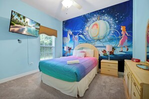 A bedroom with a bed, a nightstand, a dresser, a wall-mounted TV, and a large wall mural. - Dazzling Disney Getaway - Closest to Disney  Villa with Private Pool & Game Room (Kissimmee)