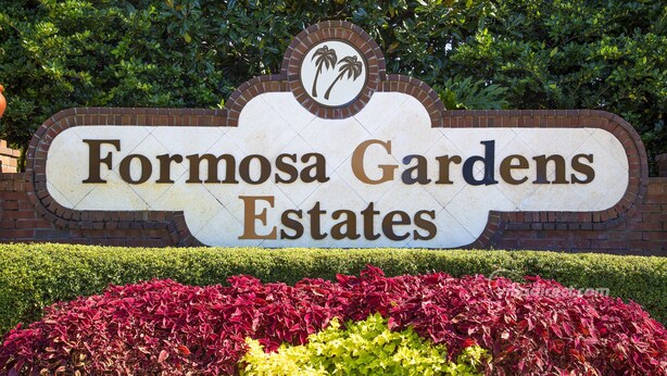 Une enseigne pour le lotissement Formosa Gardens Estates, avec une arche en briques et un logo représentant un palmier.