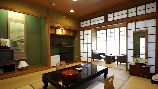 Una habitación japonesa tradicional con suelo de tatami, una mesa baja, sillas, un televisor y puertas correderas.