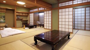 Una habitación tradicional japonesa con suelo de tatami, una mesa de madera baja, un futón y puertas correderas shoji.