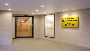 A hotel reception area with a reception desk, a wall-mounted information board, and a sign indicating the hotel's name. - Leo Plaza Hotel Sasebo (Sasebo)