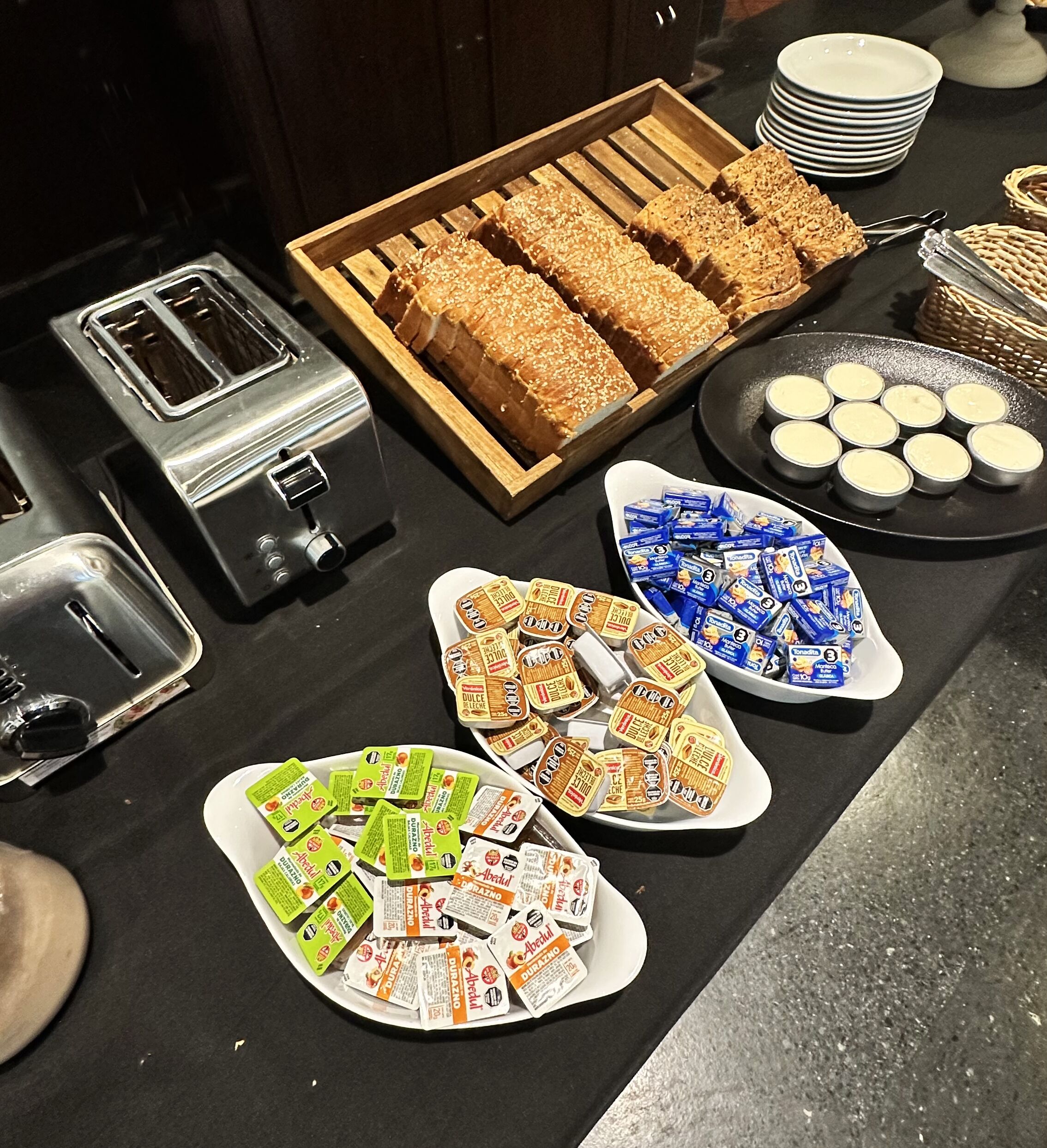 En buffetvogn med forskelligt mad, blandt andet brød, dip og pakker med snacks.