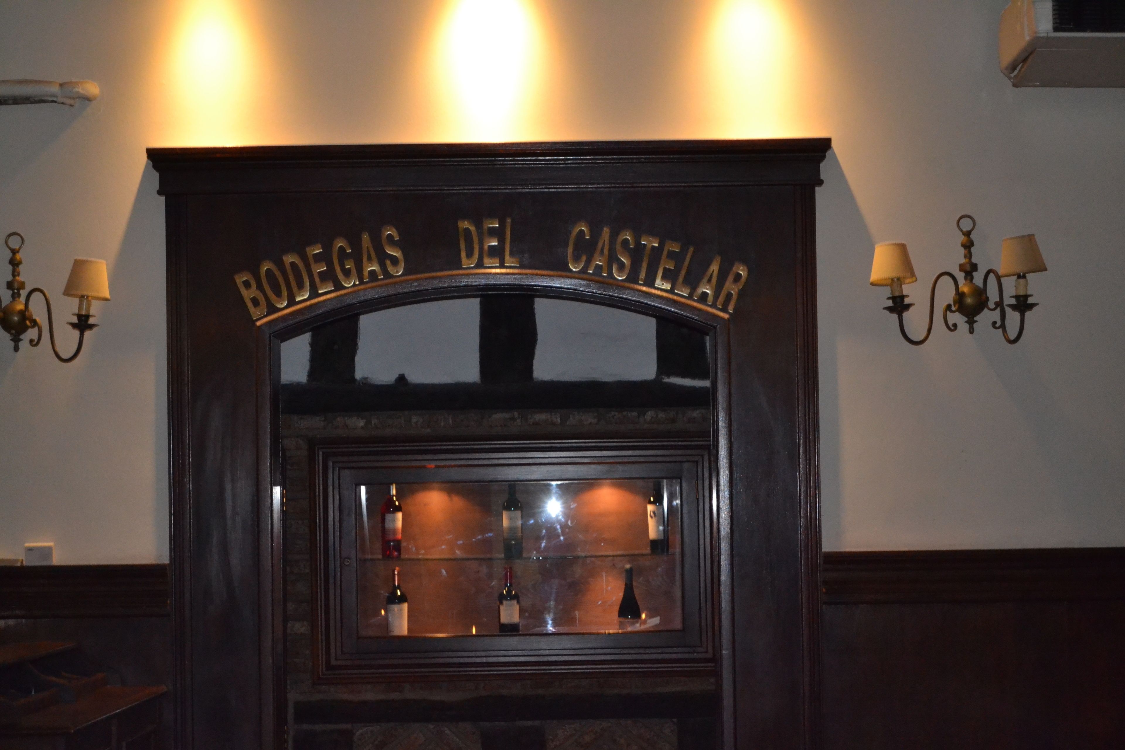 A wine rack with bottles labeled "BODEGAS DEL CASTELAR".