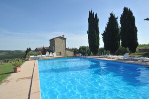 Una piscina al aire libre de temporada, sombrillas