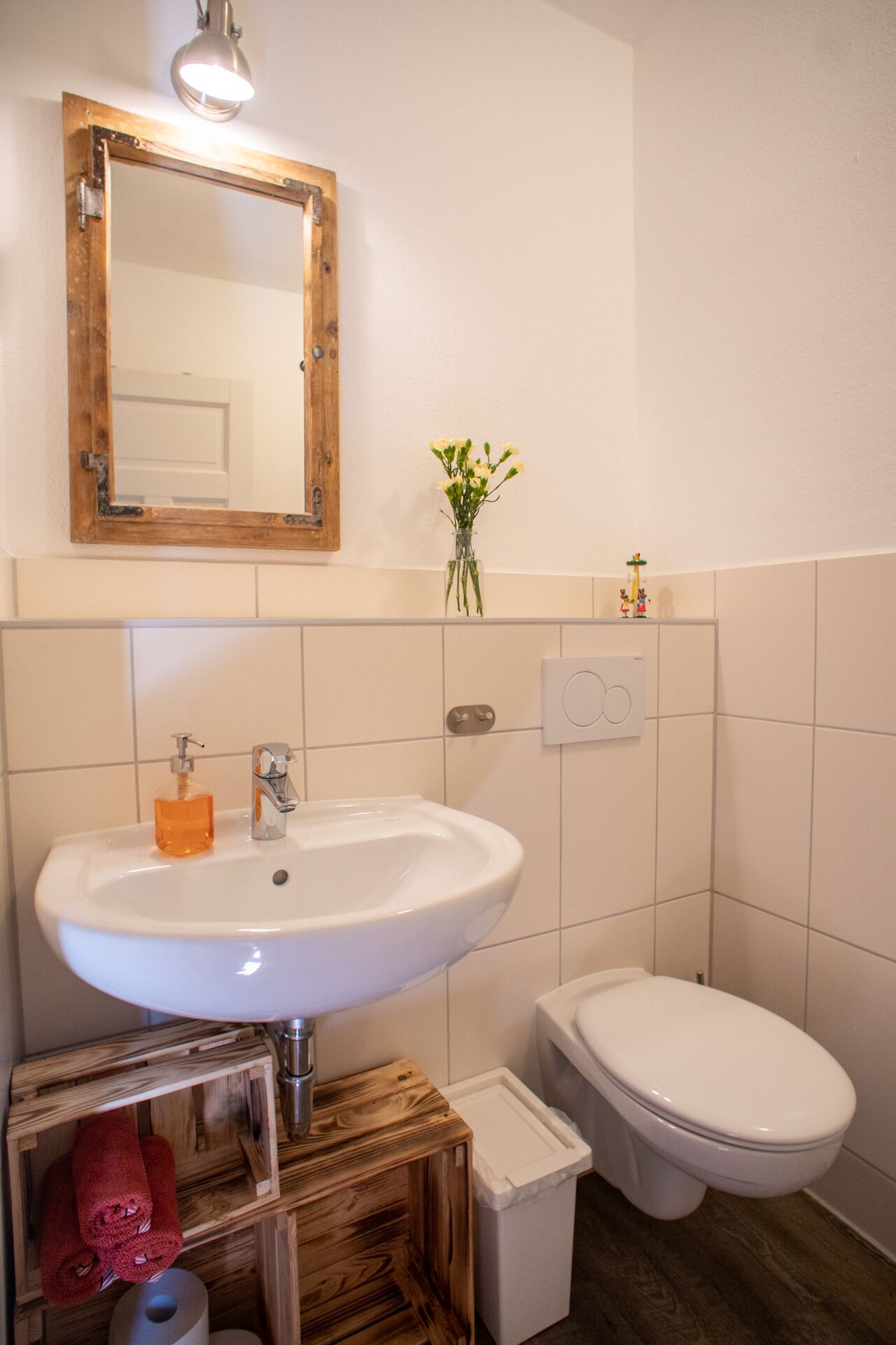 A bathroom with a white sink, a toilet, and a wooden vanity.