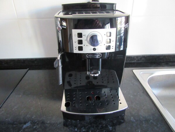 A coffee maker with a digital display, a water reservoir, and a drip tray.