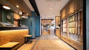 A modern interior with wooden flooring, a reception area with a counter, and shelves displaying various products.