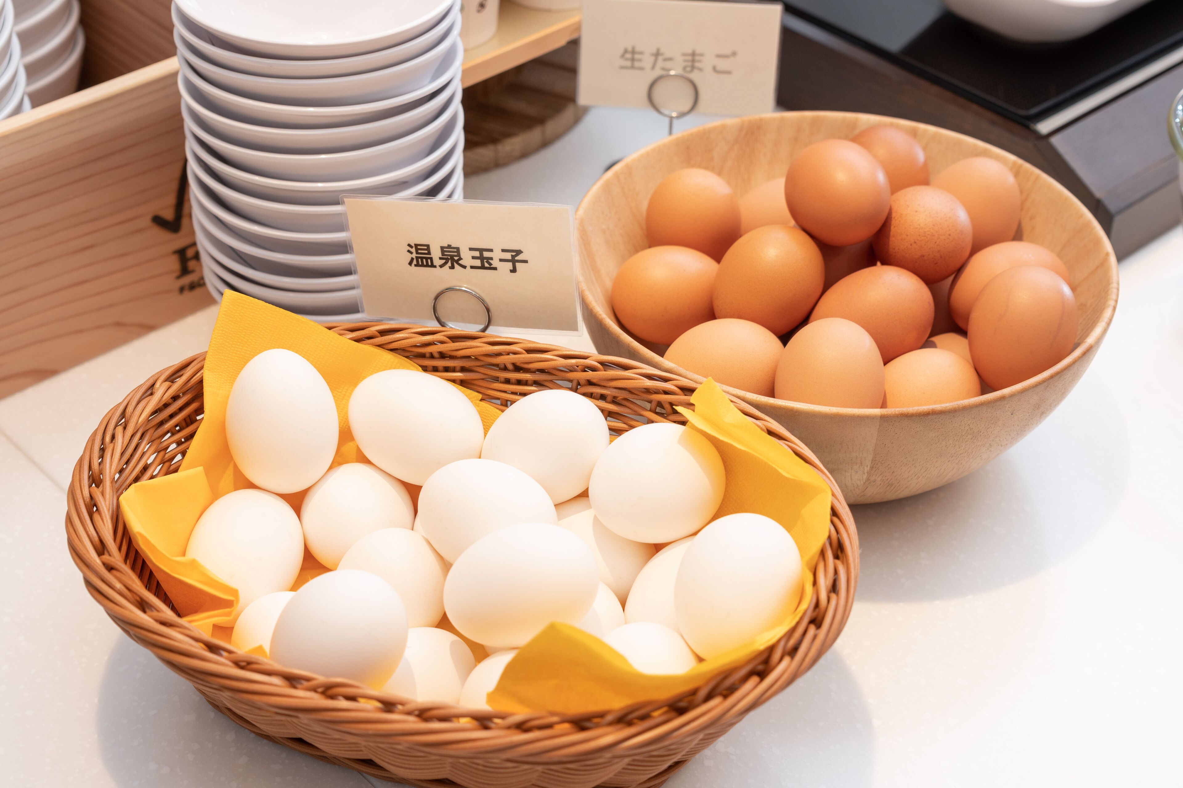 A display of eggs in wicker baskets and a bowl, with labels in a foreign language.