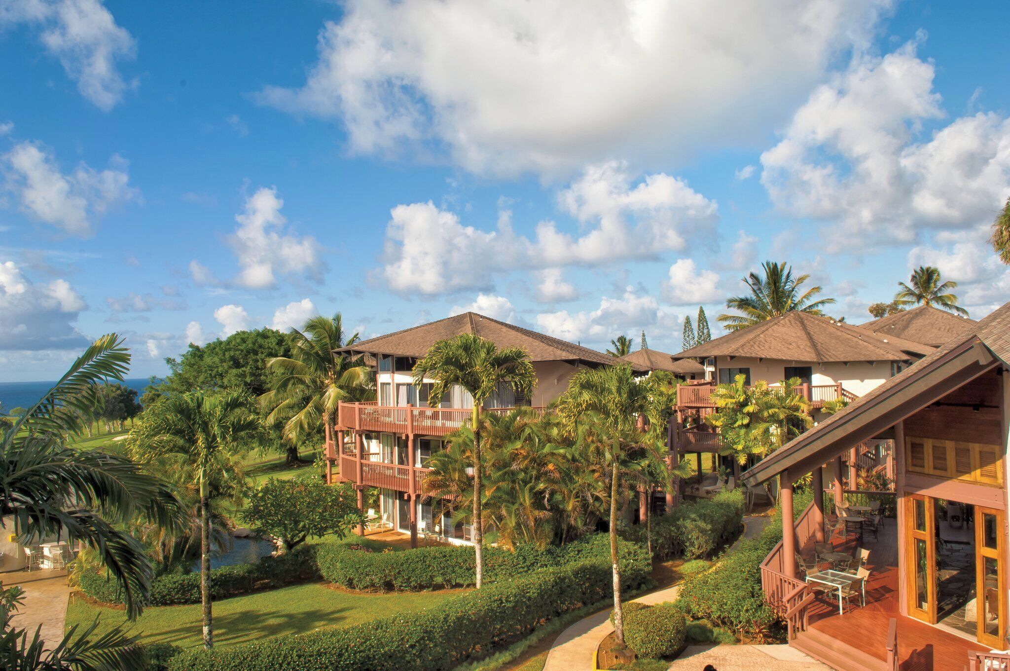 A resort with multiple buildings, lush greenery, and a clear sky.