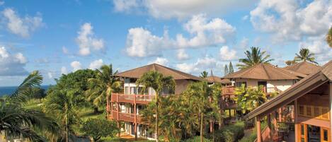 A resort with multiple buildings, lush greenery, and a clear sky.