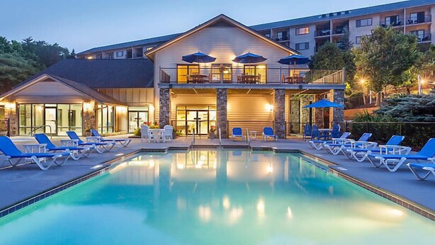 A hotel with a swimming pool, lounge chairs, and outdoor seating. - Laurel Crest Vacation Resort in the Smoky Mountains. (Pigeon Forge)