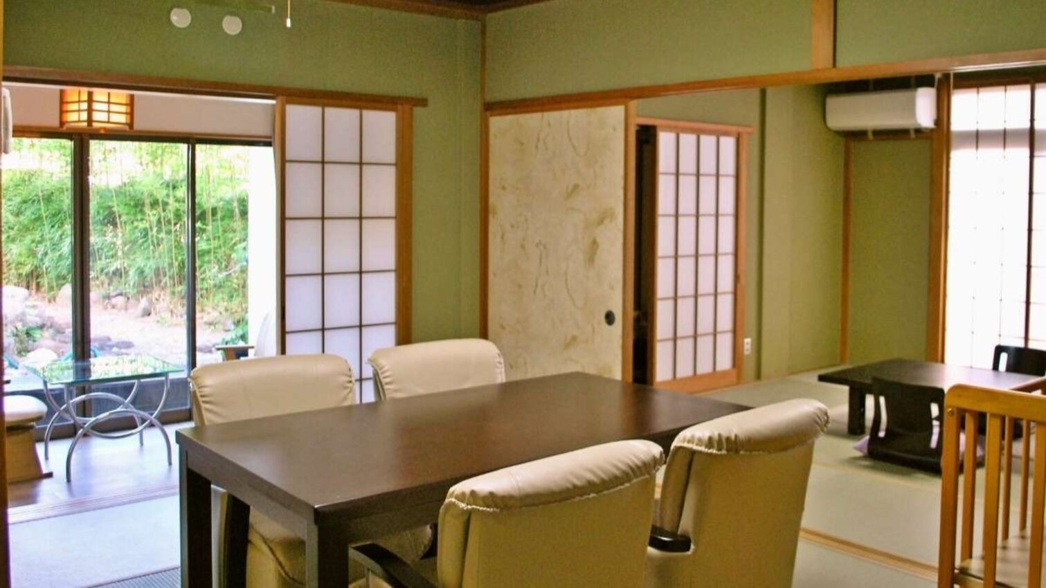 A traditional Japanese-style room with tatami flooring, a low table, and sliding doors.