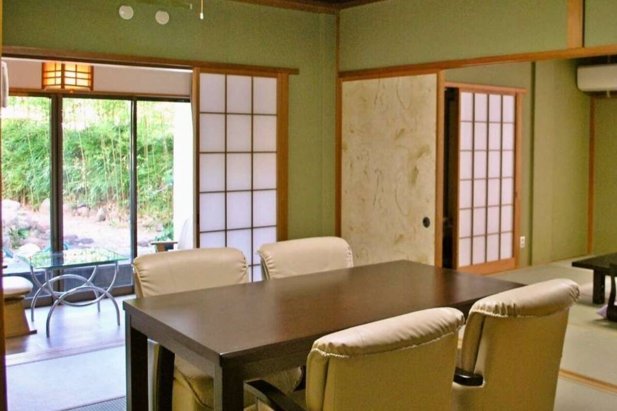 Une pièce de style japonais traditionnel, avec un sol recouvert de tatamis, une table basse et des portes coulissantes.