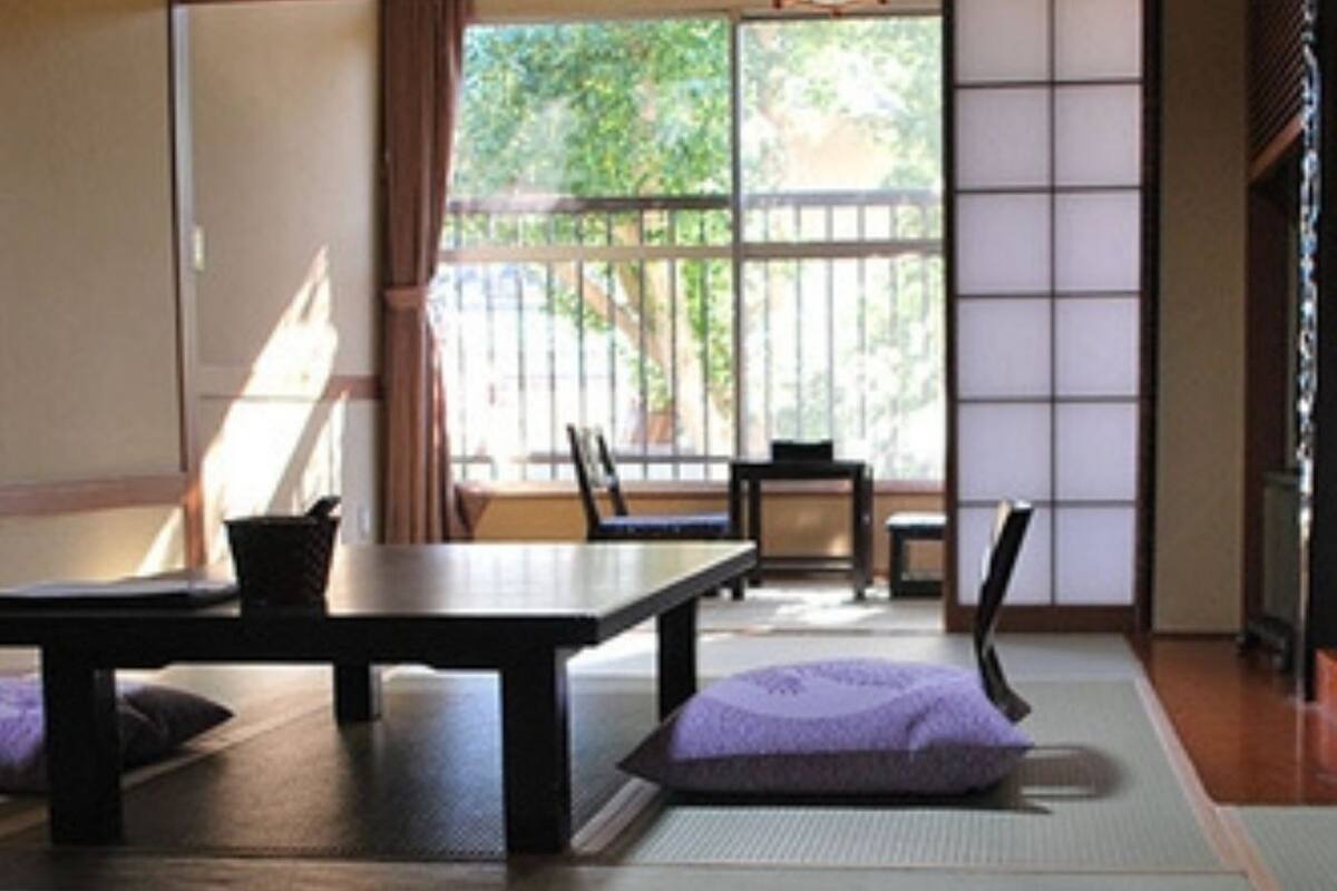 Une pièce de style japonais traditionnel, avec un sol recouvert de tatamis, une table basse et des chaises.