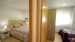 Une chambre à coucher avec un lit, une table de chevet, une lampe et une fenêtre avec des stores.