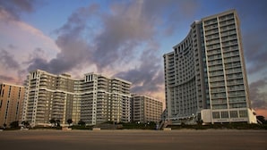 A multi-story hotel with a curved facade, located near a beach. - Spacious Oceanfront Resort with Onsite Restaurant, 5 Pools, 2 indoor Pools and Beach Access (Myrtle Beach)