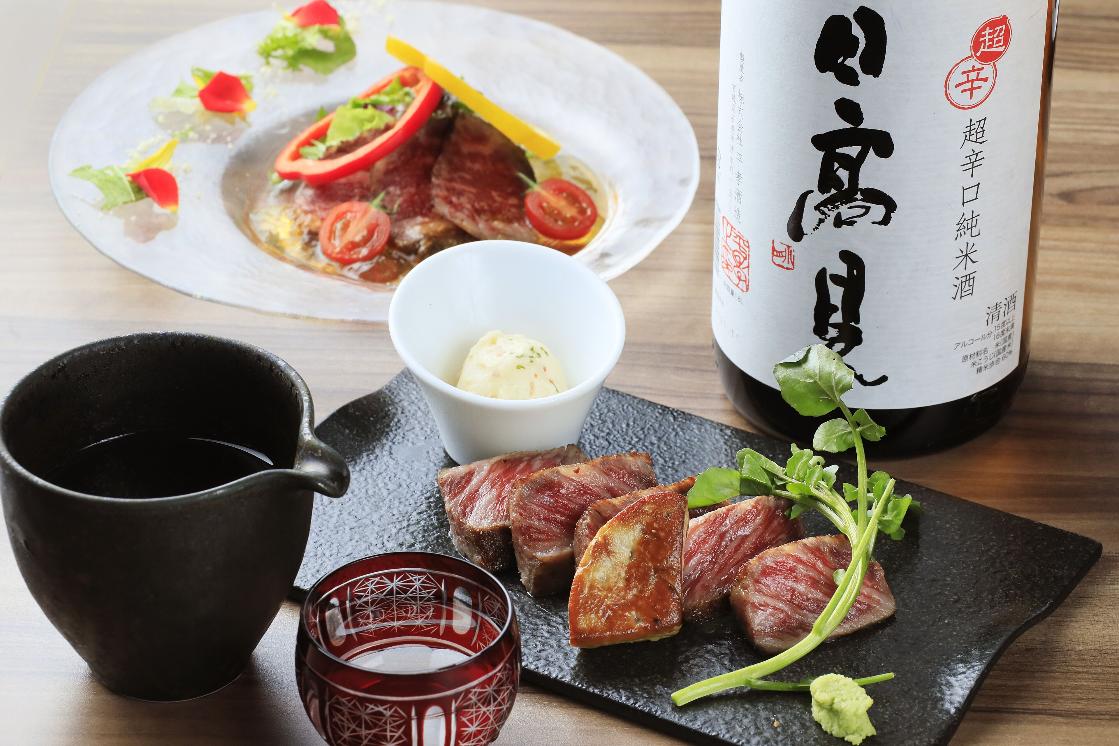 A dining table with a plate of food, a bottle of drink, a cup, and a bowl of butter.