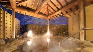 Un área de baños termales con paredes de piedra y vigas de madera.
