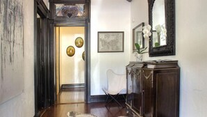 A hallway with a chandelier, a cowhide rug, a mirror, and a framed picture on the wall. - The Evers House (Fredericksburg)