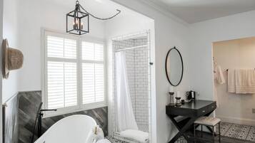 A modern bathroom with a freestanding bathtub, a walk-in shower with a glass door, and a vanity with a mirror.