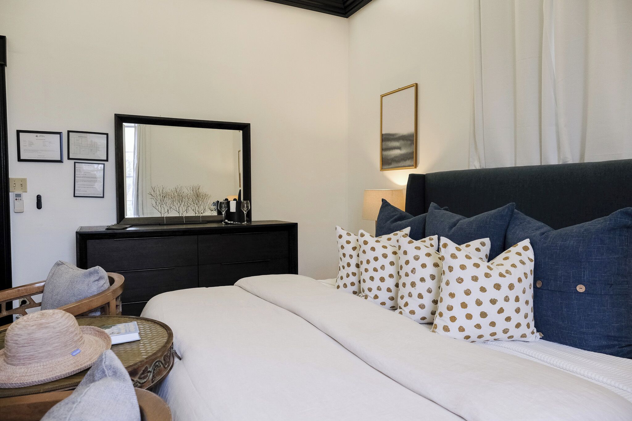 A bedroom with a bed, a dresser, a mirror, and a chair.