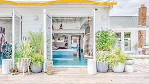 A modern building with a pool, potted plants, and a covered entrance. - The Surf Lodge (Montauk)