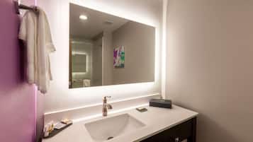 Une salle de bain moderne avec un lavabo blanc, un grand miroir et un porte-serviettes.