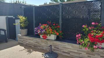 A garden area with a decorative fence, potted plants, and a seating area.