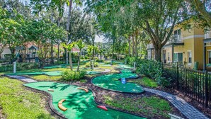 Ein Minigolfplatz, umgeben von üppigem Grün und Wohngebäuden.