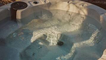A hot tub with a wooden exterior and a visible control panel.
