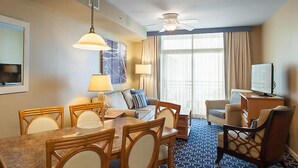 A hotel room with a dining table, chairs, a sofa, a TV, and a ceiling fan. - Located in the Heart of Myrtle Beach, close to the Beach, Museum's, with access to all amenities (Myrtle Beach)
