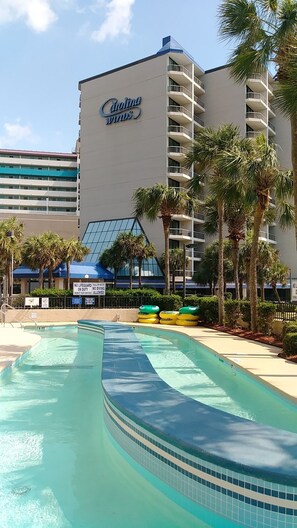A hotel with a pool area, palm trees, and a sign indicating no lifeguard on duty. - Stunning Angle Oceanfront Suite + Official On-Site Rental Privileges (Myrtle Beach)