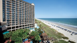 A hotel with multiple floors, a pool area, and a beach view. - Oceanfront 1 Bedroom Suite w/ Gorgeous View + Official On-Site Rental Privileges (North Myrtle Beach)
