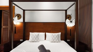 A neatly made bed with white linens and two decorative wall fans, a wooden headboard, and a wooden floor. - Emotion2 - Brand New 3BR Pool Villa (Tambon Rawai)