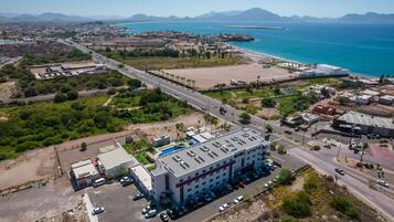 Vista aérea de una zona costera con un complejo de edificios grande, carreteras y una playa.