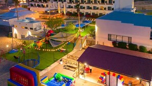 A hotel with multiple floors, outdoor swimming pool, and children's play area. - Sawari Hotel (San Carlos)