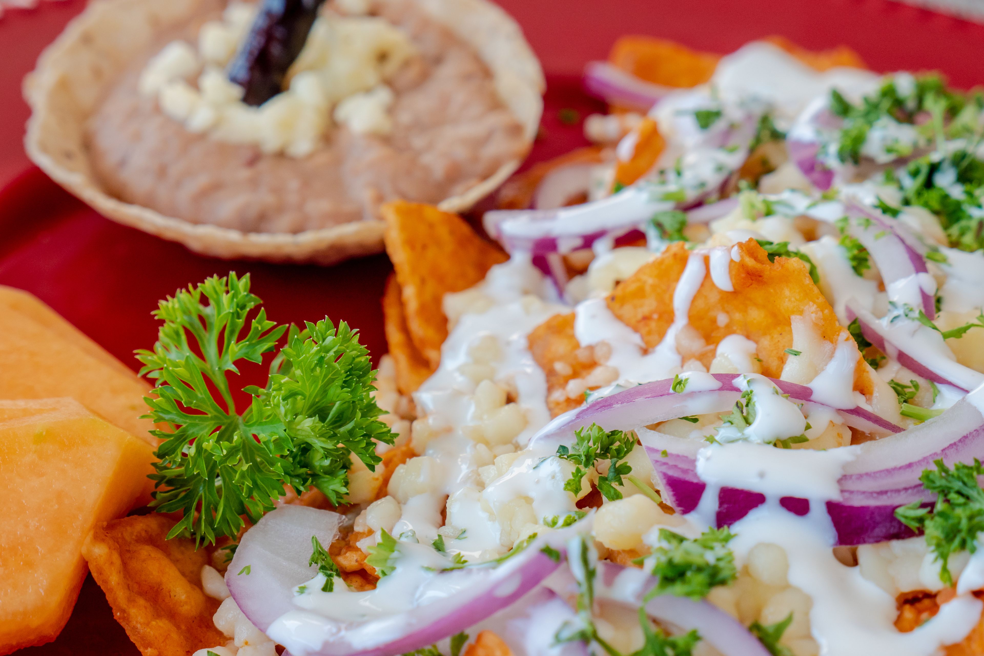 Een close-up van een gerecht met diverse toppings en een bijgerecht dat lijkt op een dipsaus.