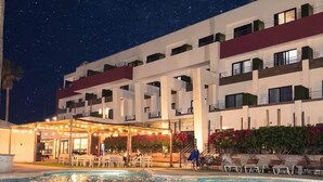 A hotel with a swimming pool, outdoor seating, and a night sky. - Sawari Hotel (San Carlos)