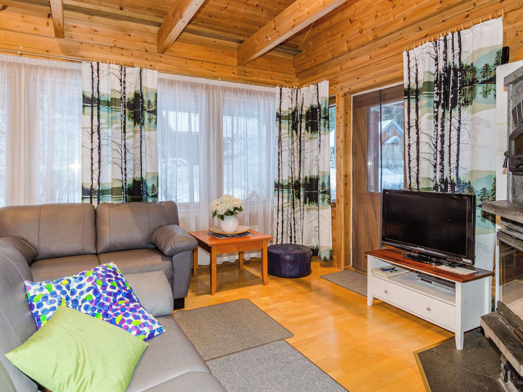 Ein gemütliches Wohnzimmer mit Sofa, Couchtisch, Fernseher und Kamin.