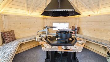 Un ambiente acogedor con una mesa central, una estufa y zonas de estar.