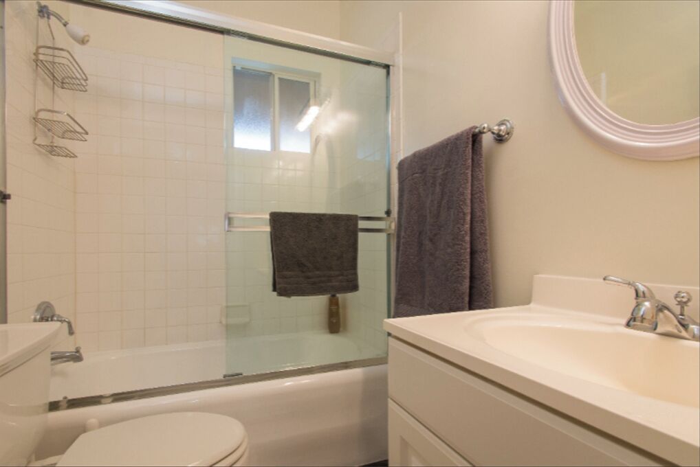 A bathroom with a bathtub, toilet, and sink.